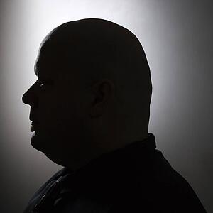 Mid adult bald man in silhouette