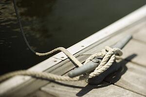 Rope tied to cleat on boat dock