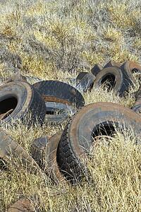 Old dirty abandoned tires in field