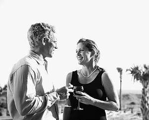 couple holding wine glasses and smiling at each other