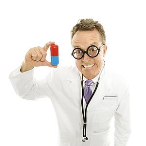 Mid-adult male doctor wearing eyeglasses holding an oversized pill