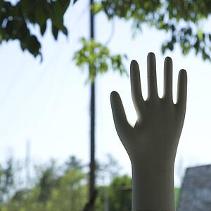 Hand statue silhouetted against sky
