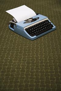 Vintage blue typewriter on green carpet