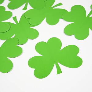 Group of green paper shamrocks on white.
