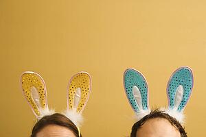 Mid adult couple wearing rabbit ears.