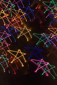 Multicolored lights forming abstract star pattern from motion blur