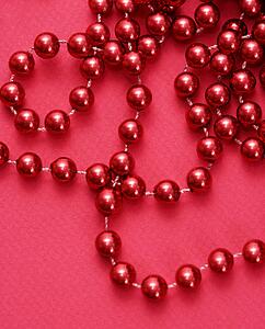 String of red beads on red background