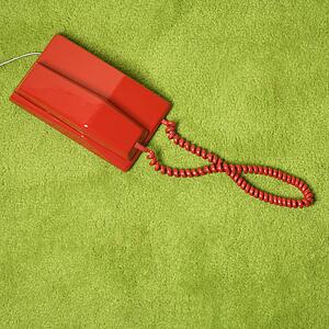 Red vintage telephone on 70's green carpet