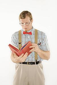 Young man dressed like nerd reading book