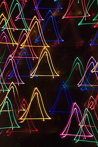 Multicolored lights forming abstract triangle pattern from motion blur