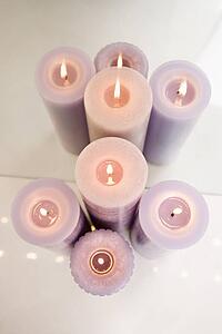 Overview of purple burning candles in front of mirror