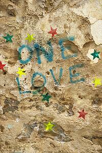 Concrete wall with graffiti stating 'One Love'