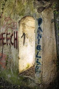 Doorway of abandoned building with spray painted graffiti