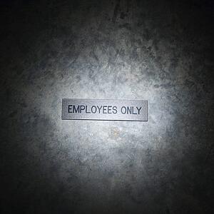 Metal employees only sign on textured background