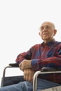Man sitting in wheelchair with hands clasped