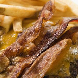 Close up of bacon cheeseburger with french fries