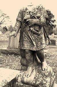 Statue in graveyard of headless cherub