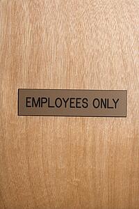 Employees only sign on wooden door