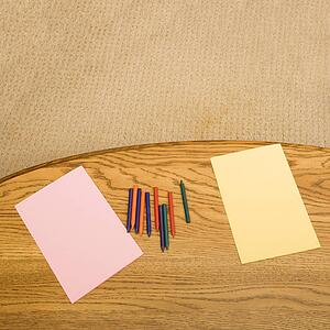 Construction paper and crayons on table
