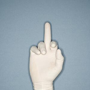 Hand wearing white rubber glove with middle finger extended making profane gesture