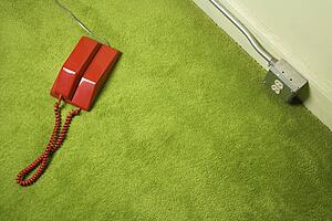 Red vintage telephone on 70's green carpet