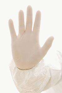 Hand wearing white rubber glove.