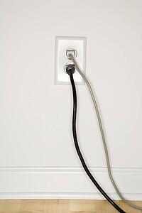 Two cords plugged into electrical wall outlet
