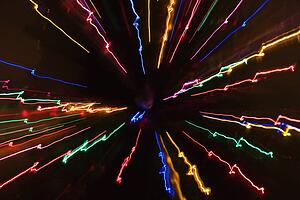 Multicolored lights forming abstract radial starburst pattern from motion blur