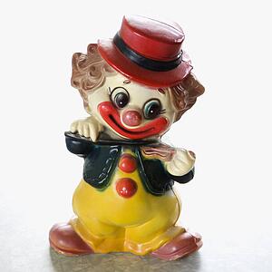 Still life of vintage colorful smiling clown figurine playing the violin