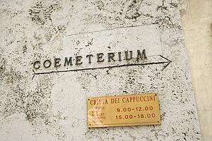 Sign with arrow directing towards coemeterium in Rome, Italy