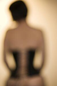Blurred rear view shot of young woman wearing corset