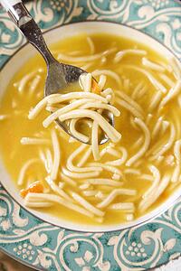 Bowl of chicken noodle soup with spoon