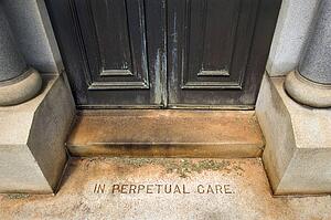 Entrance to mausoleum in graveyard with words, 'In Perpetual Care'