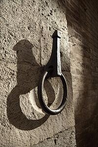 Metal hitching post on stone wall