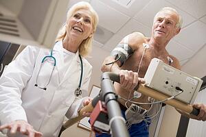 Doctor Monitoring The Heart-Rate Of Patient On A Treadmill