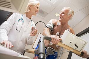 Doctor Monitoring The Heart-Rate Of Patient On A Treadmill