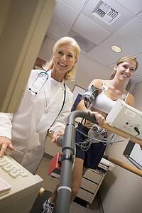 Doctor Monitoring The Heart-Rate Of Patient On A Treadmill