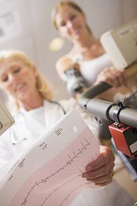Doctor Monitoring The Heart-Rate Of Patient On A Treadmill