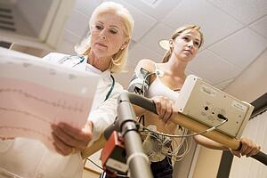 Doctor Monitoring The Heart-Rate Of Patient On A Treadmill