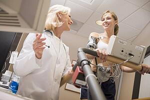 Doctor Monitoring The Heart-Rate Of Patient On A Treadmill
