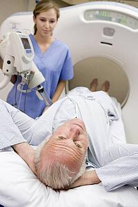 Nurse With Patient As They Prepare For A Computerized Axial Tomography (CAT) Scan