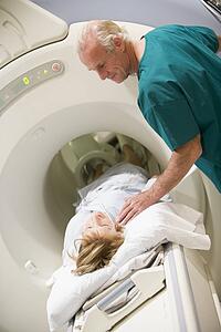 Doctor With Patient As They Prepare For A Computerized Axial Tomography (CAT) Scan
