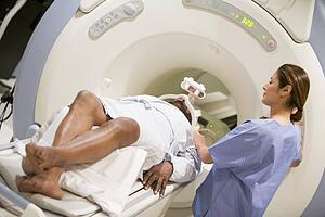 Nurse With Patient As They Prepare For A Computerized Axial Tomography (CAT) Scan