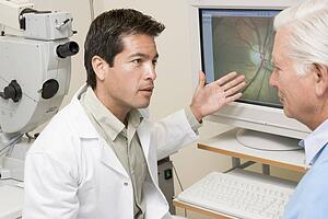 Doctor Explaining Eye Exam Results To Patient