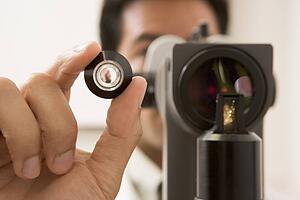 Doctor Looking Through Eye Exam Machine 