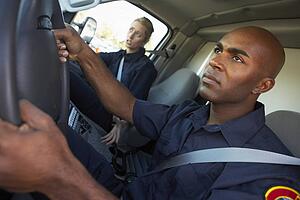 Ambulance driver and colleague on the way to an emergency