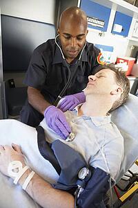 Paramedic attending to patient in ambulance