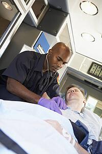 Paramedic attending to patient in ambulance