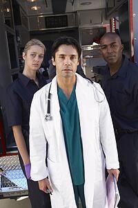Portrait of doctor with two paramedics in front of ambulance