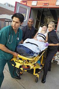 Paramedics and doctor unloading patient from ambulance